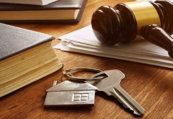 Property law concept. Key from real estate and gavel.