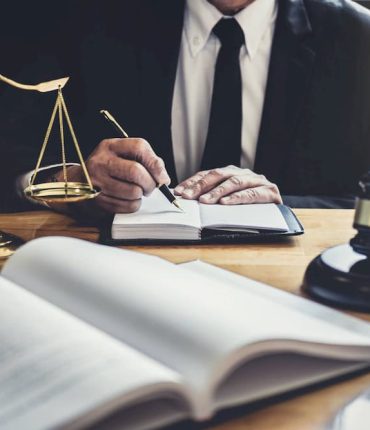 male-lawyer-or-judge-working-with-contract-papers-5ZV28KL