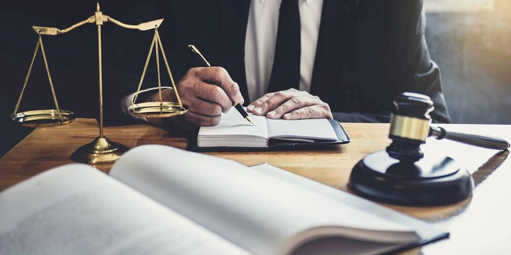 male-lawyer-or-judge-working-with-contract-papers-5ZV28KL